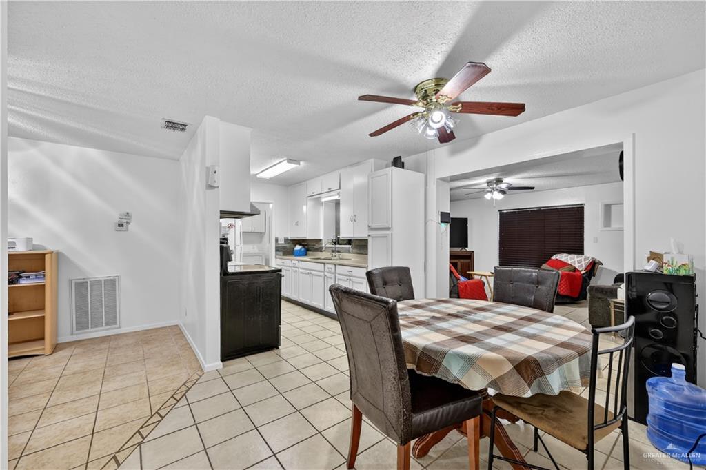 616 5th Street Weslaco, TX 78596 - Photo 21 of 33 a view of a dining room and livingroom with furniture a chandelier fan and a kitchen view