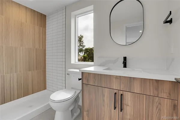 a bathroom with a toilet a sink and a mirror