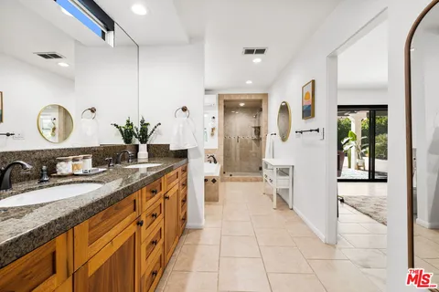 a spacious bathroom with a granite countertop sink and a mirror
