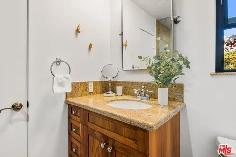 a bathroom with a granite countertop sink and a mirror