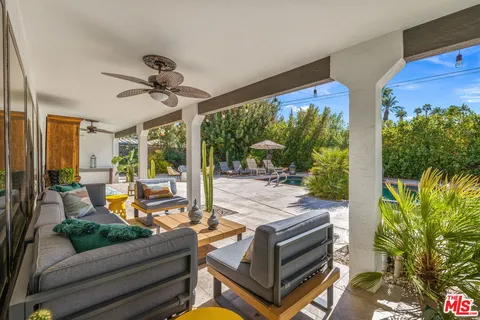 a living room with patio furniture and a floor to ceiling window