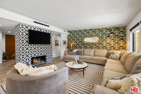 a living room with furniture a flat screen tv and a fireplace