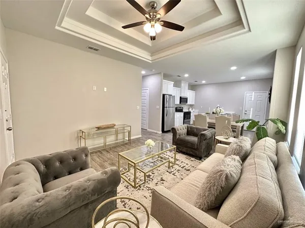 a living room with furniture kitchen view and a chandelier
