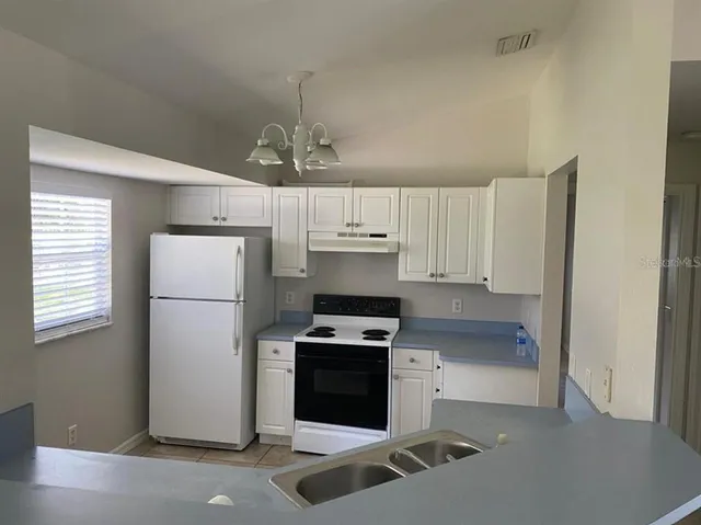 a kitchen with a refrigerator and a stove