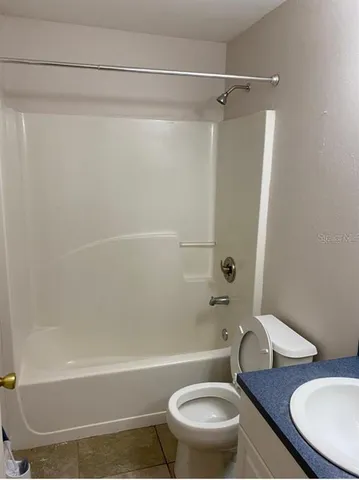 a white toilet sitting next to a bath tub and a shower