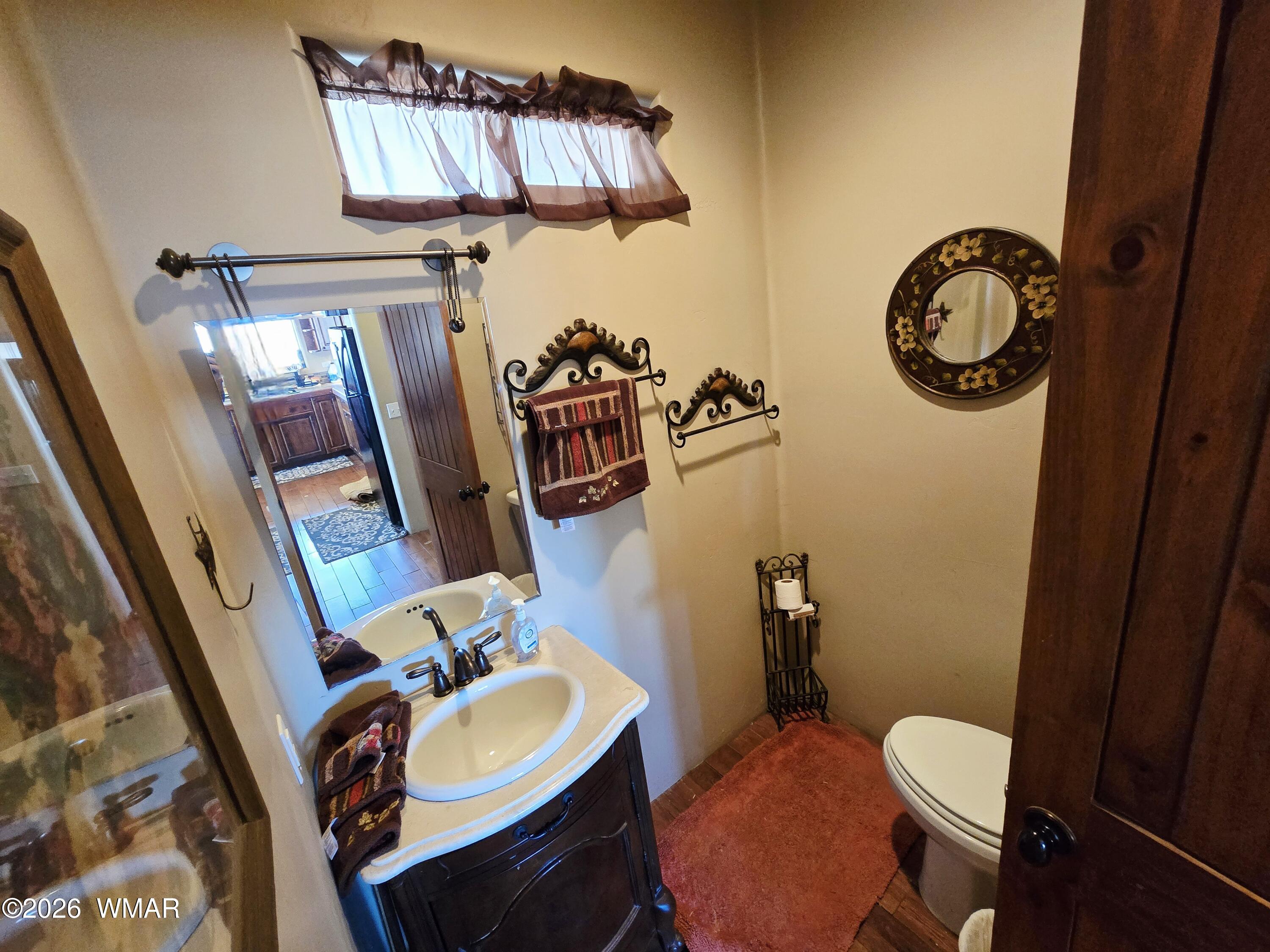 9046 Miller Trail Snowflake, AZ 85937 - Photo 11 of 34 a bathroom with a toilet a sink and mirror