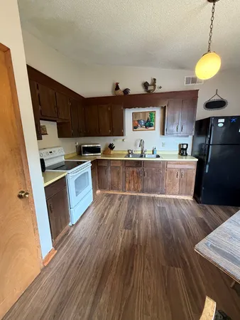 a kitchen with stainless steel appliances granite countertop a stove and a wooden floors