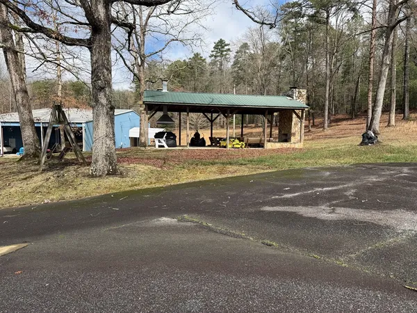 a view of a house with a yard and large trees