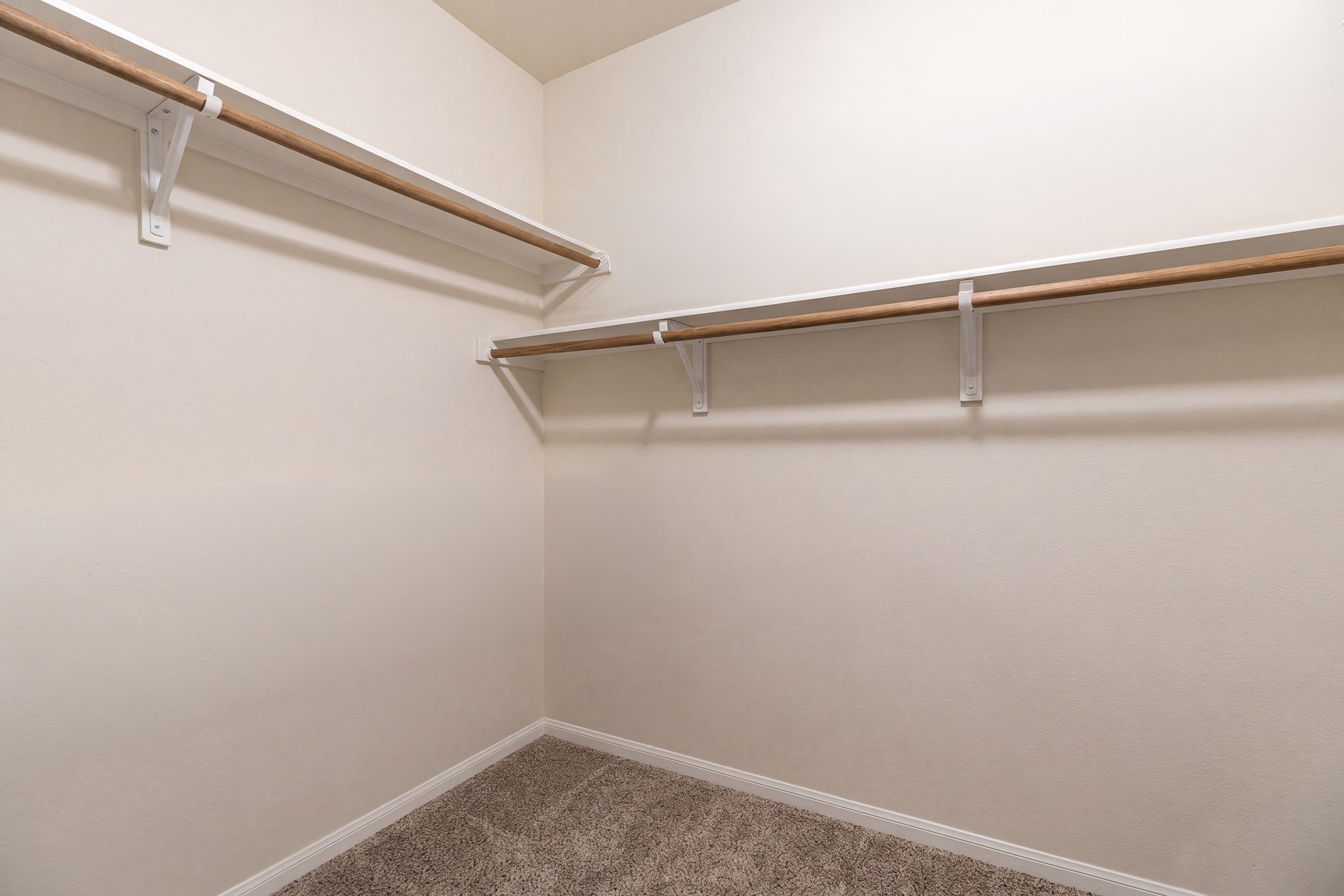 79 West Jagged Ridge Circle Spring, TX 77389 - Photo 27 of 50 The primary walk-in closet offers generous space and built-in wood shelving and rods for excellent organization. With room for an extensive wardrobe, this closet adds everyday convenience and a touch of luxury to the primary suite.