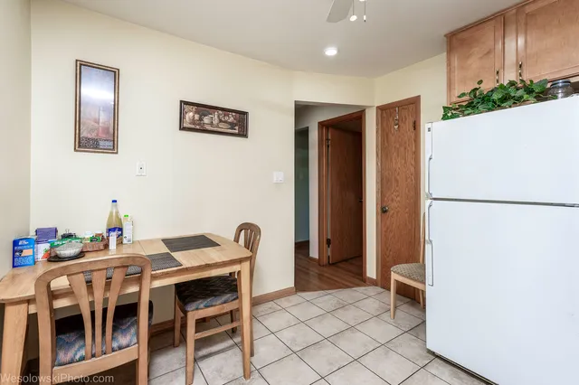a dining room with furniture and a refrigerator