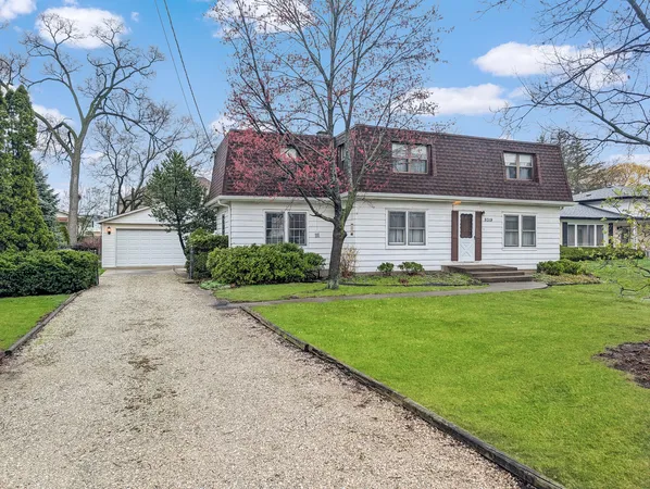 a front view of a house with a yard and trees