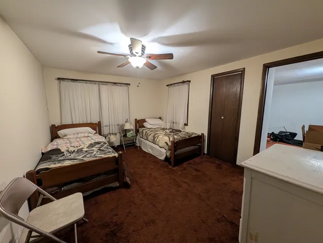 a room with furniture a flat screen tv and a ceiling fan