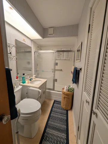 a bathroom with a sink a toilet a mirror and shower