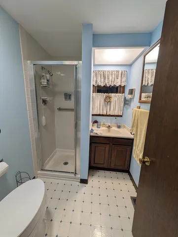 a bathroom with a granite countertop sink toilet and shower