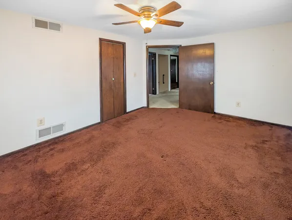 a view of a big room with closet and chandelier fan
