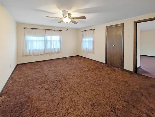 an empty room with windows and closet