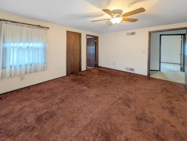 an empty room with fan and windows