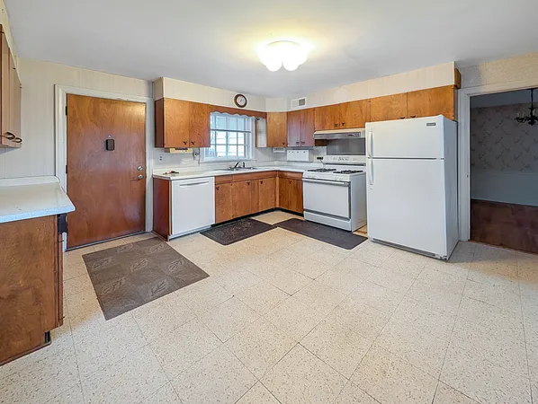 a kitchen with stainless steel appliances granite countertop a refrigerator sink and white cabinets
