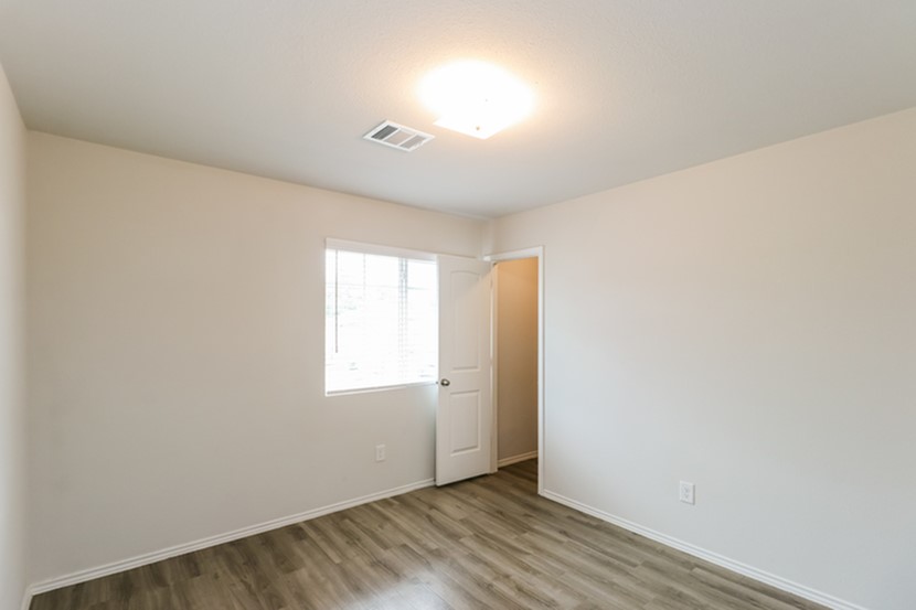 2744 Madison Court Willis, TX 77378 - Photo 13 of 16 an empty room with wooden floor and windows