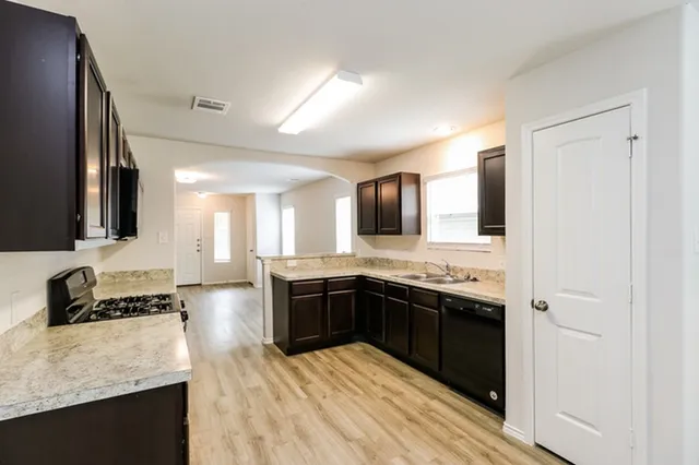 a large kitchen with stainless steel appliances granite countertop a stove and a sink