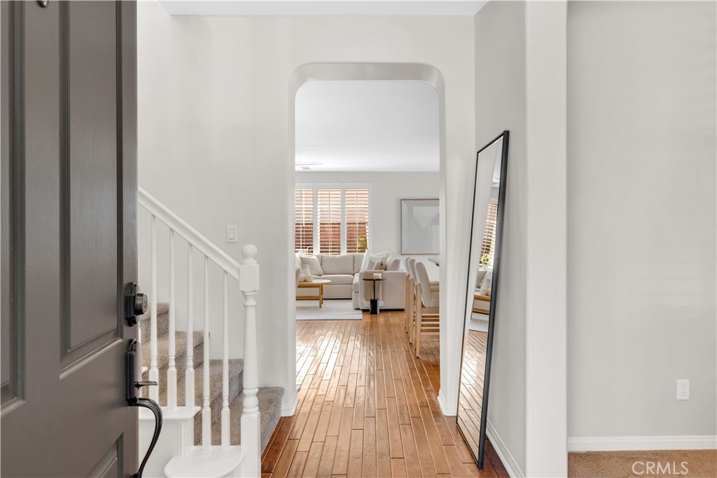 78 Dawnwood Ladera Ranch, CA 92694 - Photo 5 of 54 a view of a hallway with wooden floor and a livingroom with furniture