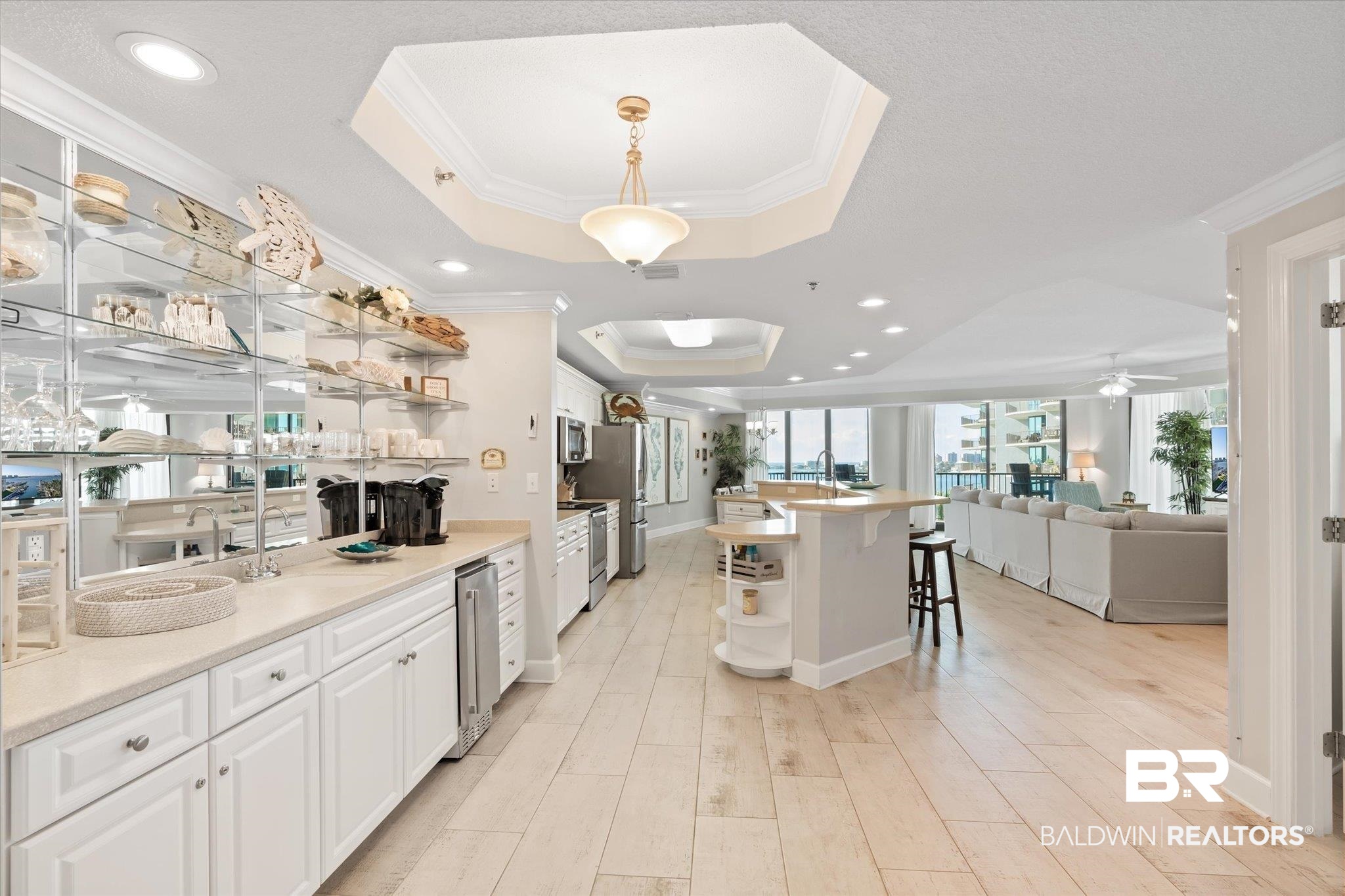 27582 Canal Road, Unit 2611 Orange Beach, AL 36561 - Photo 6 of 37 Kitchen with ceiling fan, white cabinets, a raised ceiling, ornamental molding, and a breakfast bar