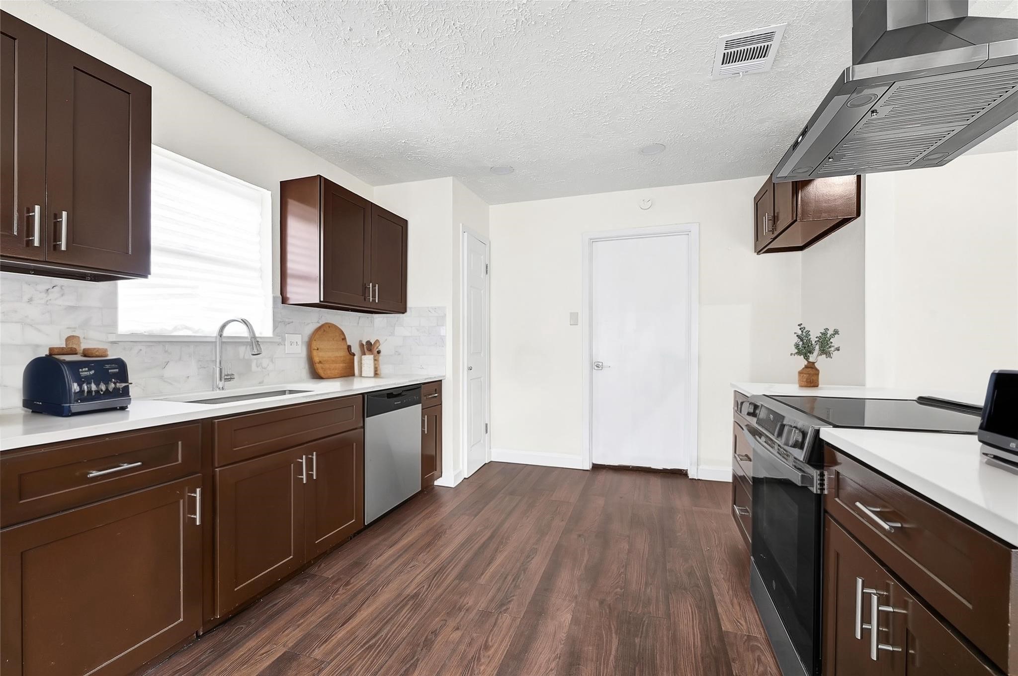 15907 Timber Valley Drive Houston, TX 77070 - Photo 14 of 27 a kitchen with a sink and wooden floor