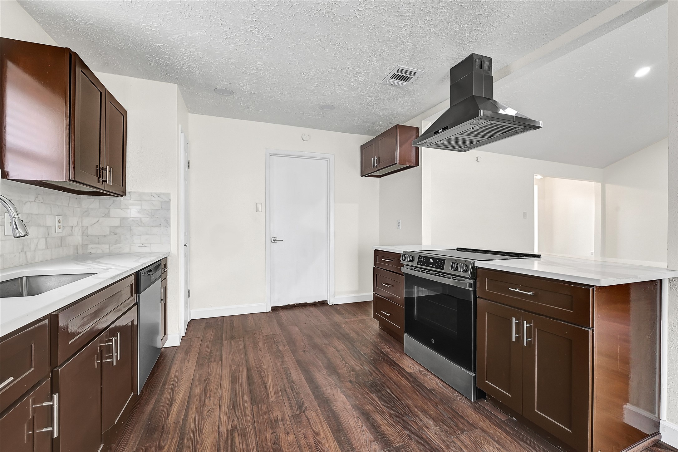15907 Timber Valley Drive Houston, TX 77070 - Photo 15 of 27 a kitchen with stainless steel appliances a sink and wooden floor
