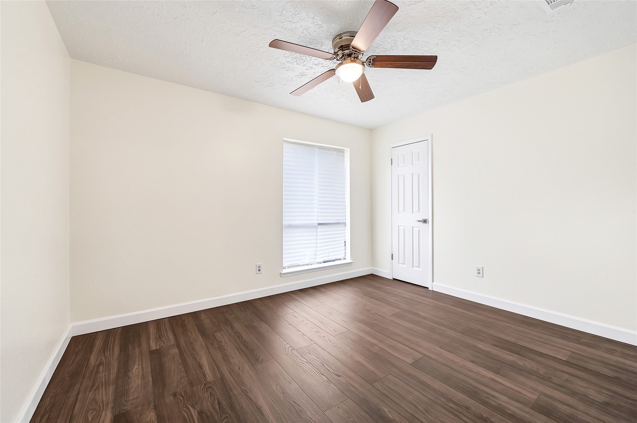 15907 Timber Valley Drive Houston, TX 77070 - Photo 16 of 27 an empty room with wooden floor ceiling fan and windows
