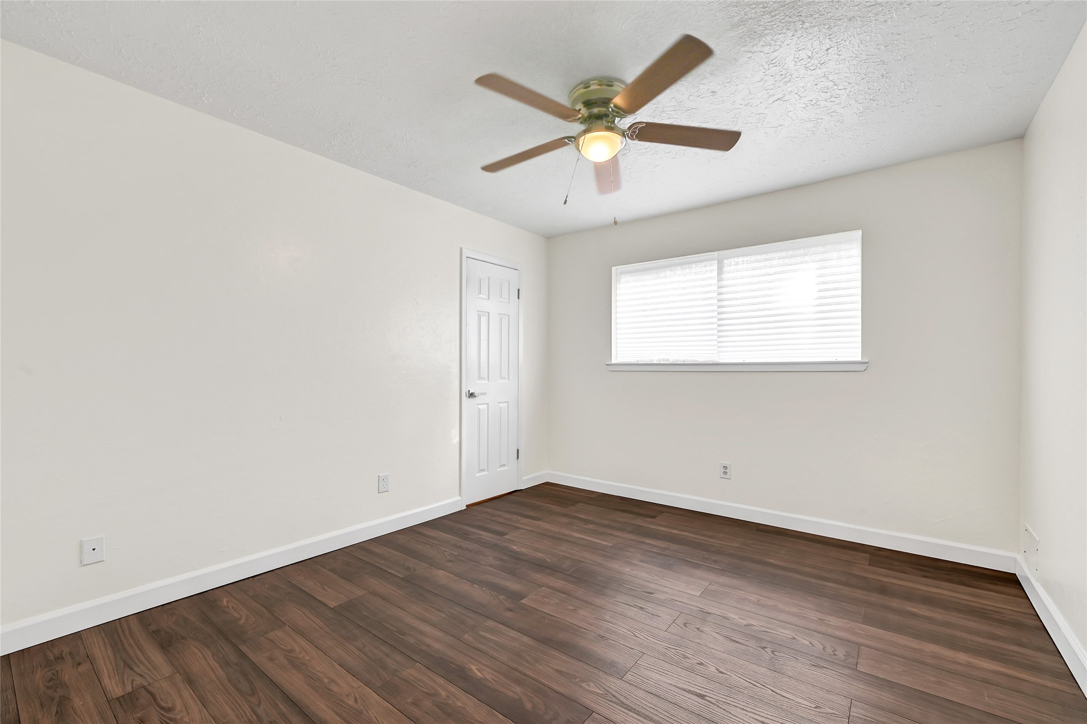 15907 Timber Valley Drive Houston, TX 77070 - Photo 18 of 27 an empty room with wooden floor and windows