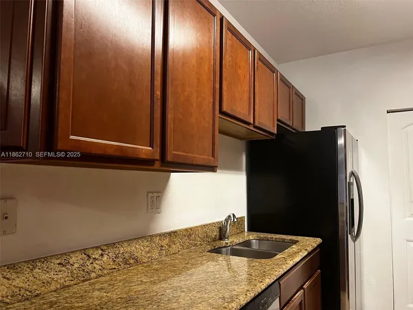 a kitchen with stainless steel appliances granite countertop a refrigerator and a sink