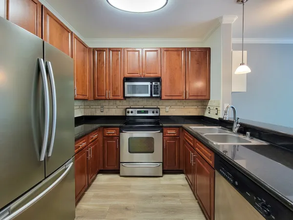 a kitchen with stainless steel appliances granite countertop a refrigerator stove and microwave