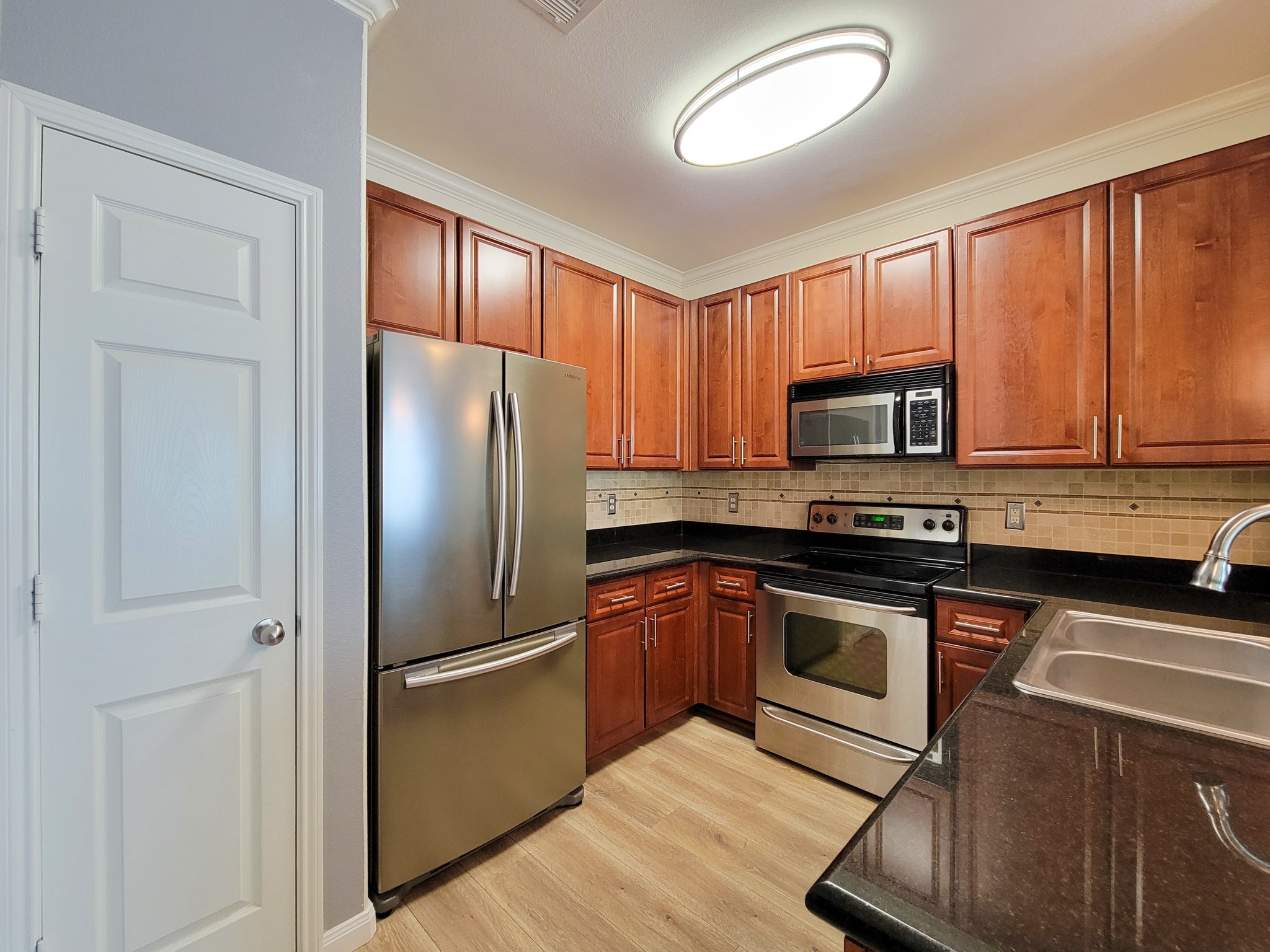 9200 Westheimer Road, Unit 305 Houston, TX 77063 - Photo 5 of 32 a kitchen with stainless steel appliances granite countertop a refrigerator stove and microwave