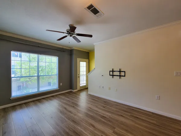 a view of a big room with wooden floor and windows