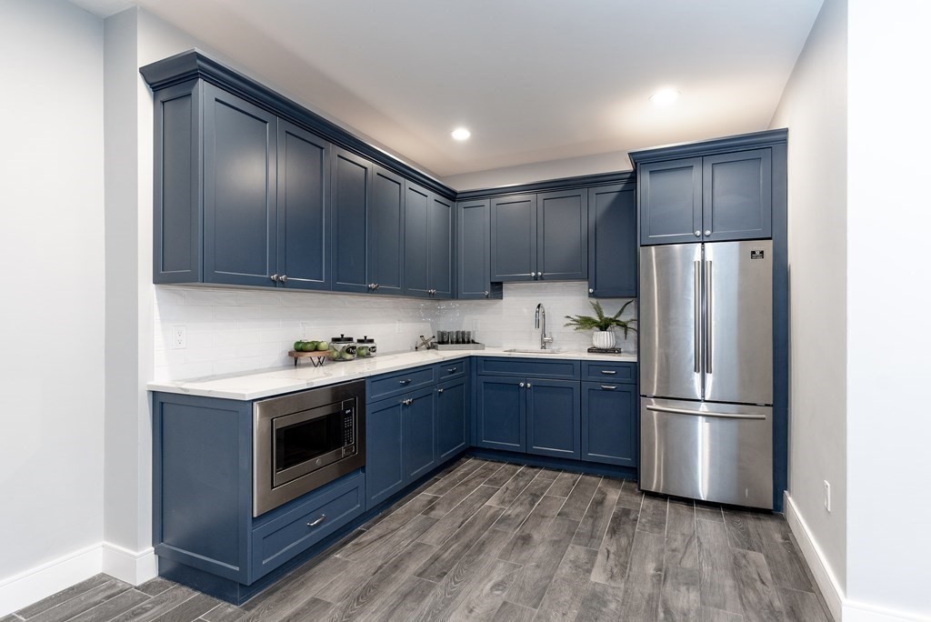 35 Wayne Road Newton, MA 02459 - Photo 28 of 33 a kitchen with stainless steel appliances granite countertop a refrigerator a stove and a wooden floors