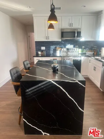 a kitchen with stainless steel appliances a stove a sink and a microwave