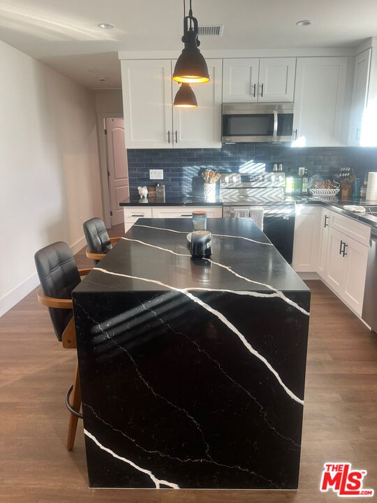 8302 Capps Avenue Northridge, CA 91324 - Photo 4 of 16 a kitchen with stainless steel appliances a stove a sink and a microwave