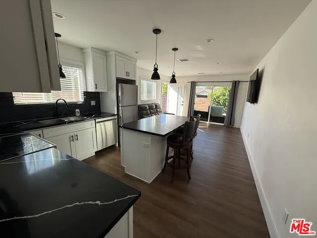 a kitchen with granite countertop a sink stove and cabinets