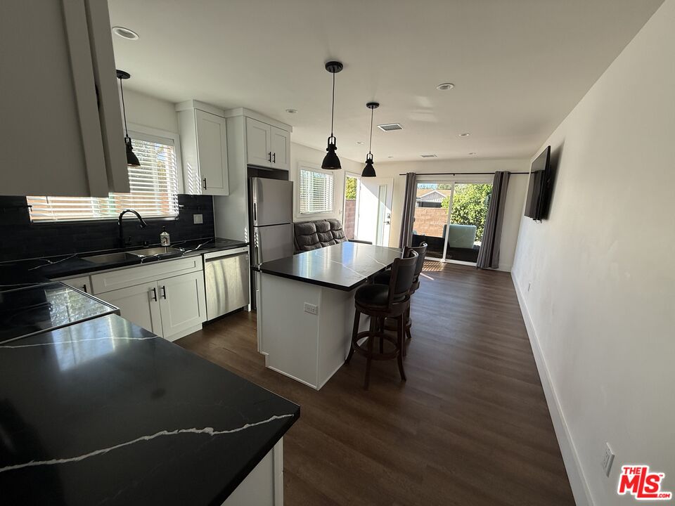 8302 Capps Avenue Northridge, CA 91324 - Photo 5 of 16 a kitchen with granite countertop a sink stove and cabinets