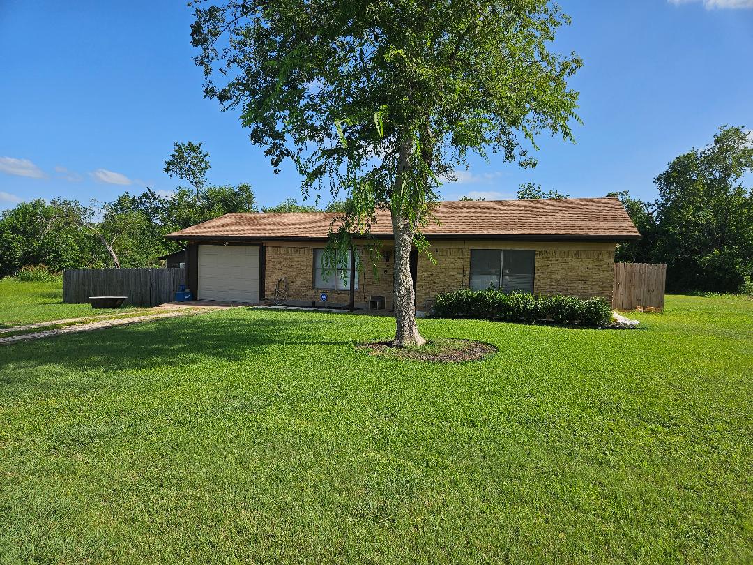 A classic brick exterior offers timeless appeal with a lush green lawn.