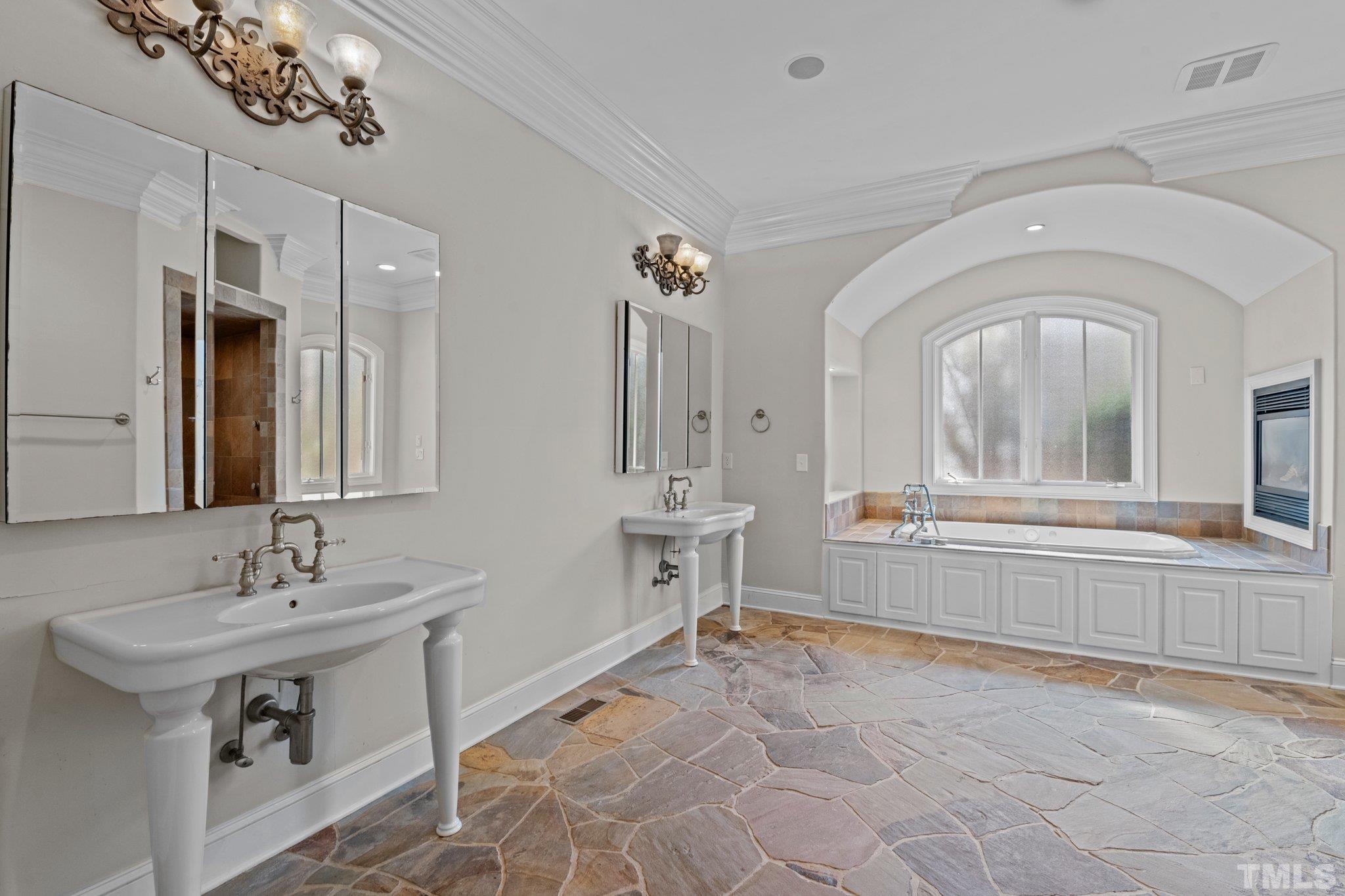12501 Village Springs Road Raleigh, NC 27614 - Photo 65 of 93 a spacious bathroom with a sink a mirror and a bathtub