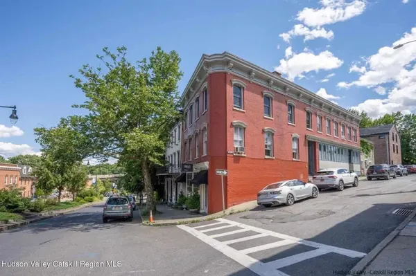 a city street lined with parked cars and buildings