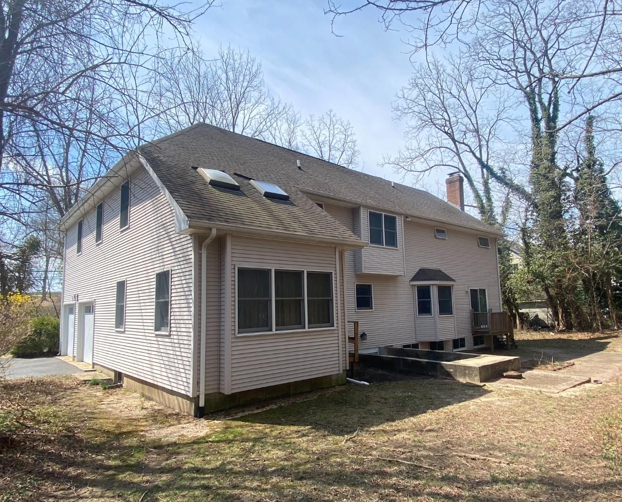 155 Lower Sheep Pasture Road Setauket, NY 11733 - Photo 3 of 8 Rear view of house featuring driveway, a chimney, a garage, and roof with shingles