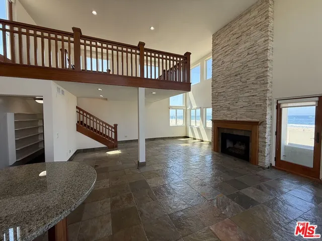 a view of a livingroom with entryway a floor to ceiling window and staircase