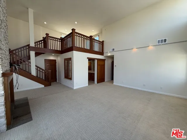 a view of a hallway with wooden floor and cabinets
