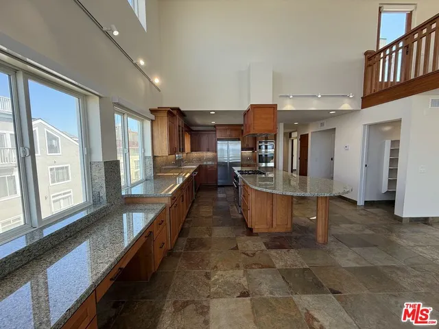 a kitchen with stainless steel appliances granite countertop a sink a stove and a refrigerator