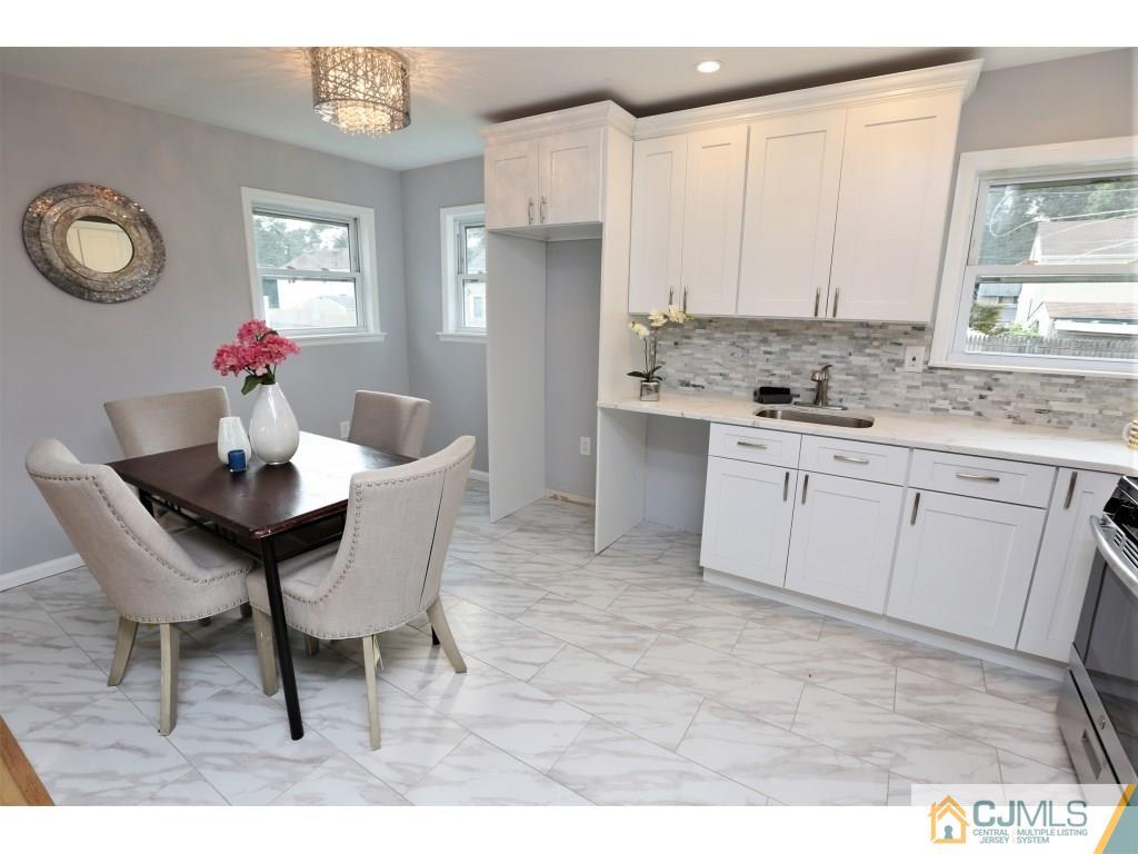 173 McFarlane Road Colonia, NJ 07067 - Photo 12 of 25 a kitchen with a dining table chairs and cabinets
