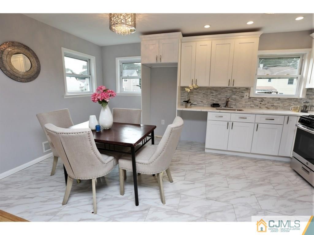 173 McFarlane Road Colonia, NJ 07067 - Photo 14 of 25 a kitchen with a dining table chairs and refrigerator