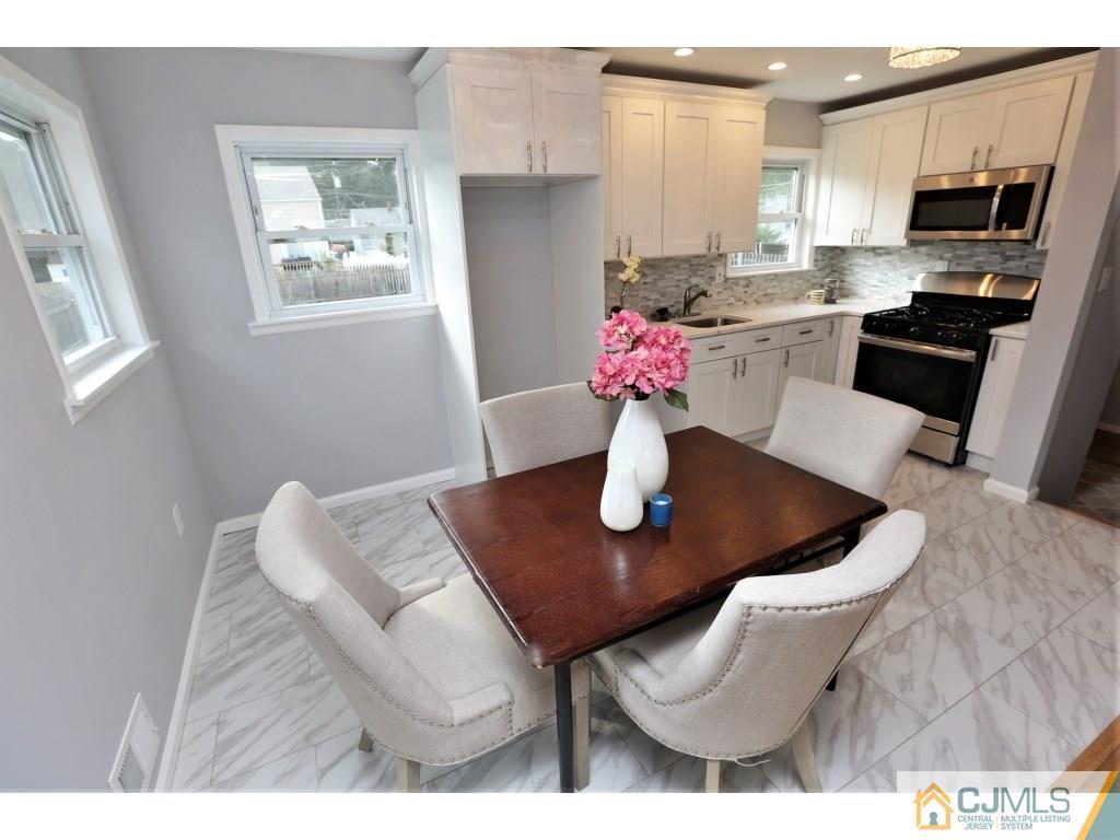 173 McFarlane Road Colonia, NJ 07067 - Photo 16 of 25 a view of dining room and kitchen island with stainless steel appliances