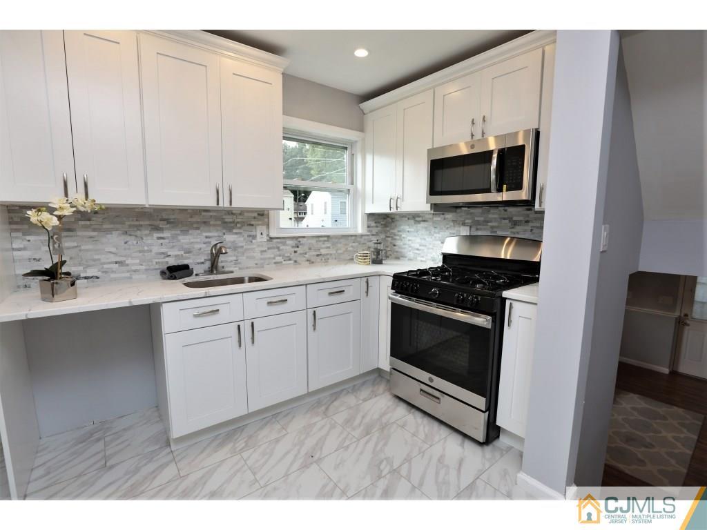 173 McFarlane Road Colonia, NJ 07067 - Photo 17 of 25 a kitchen with stainless steel appliances a stove microwave and sink